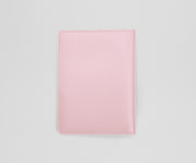 Pink leather passport holder on a light gray background