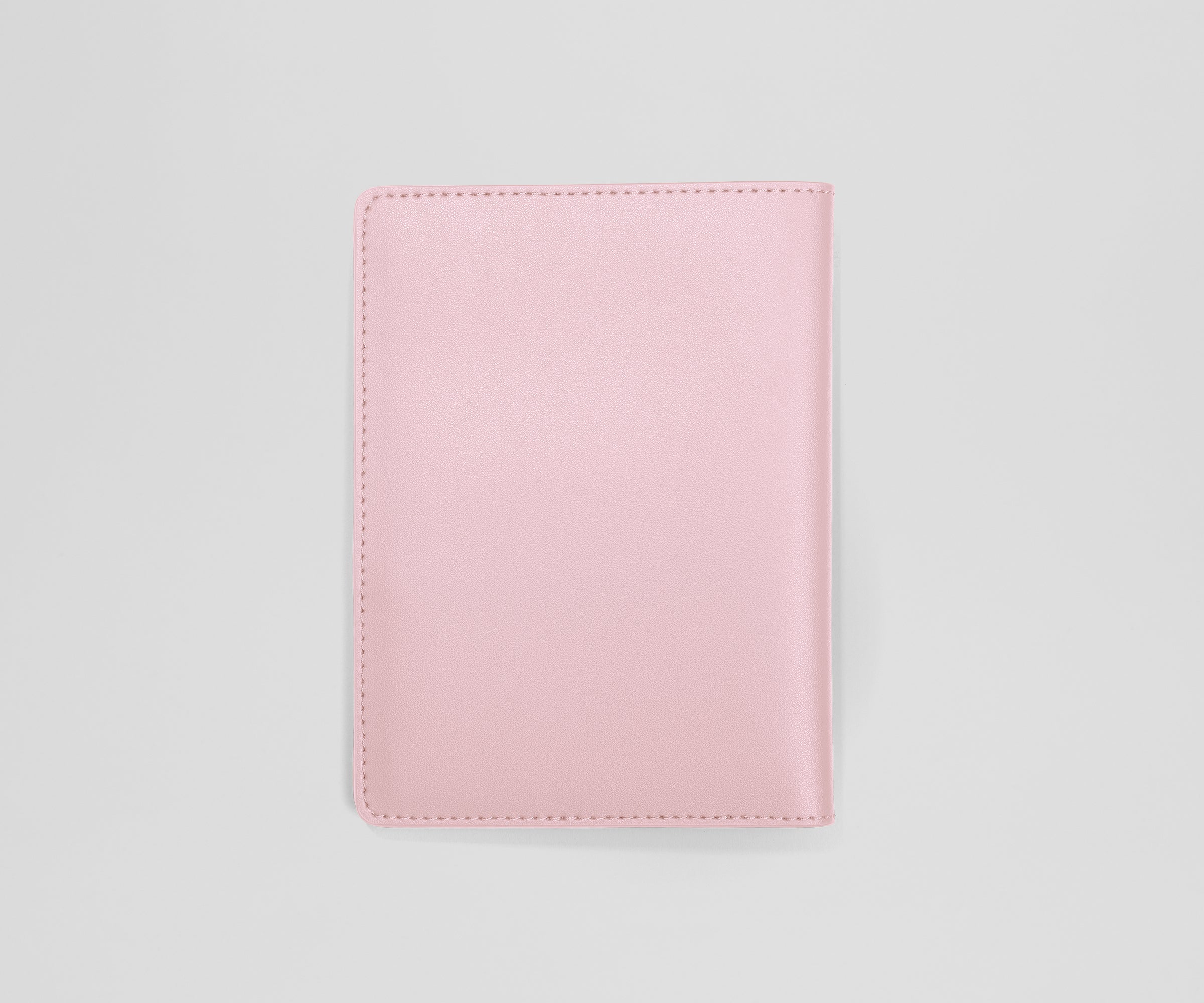 Pink leather passport holder on a light gray background