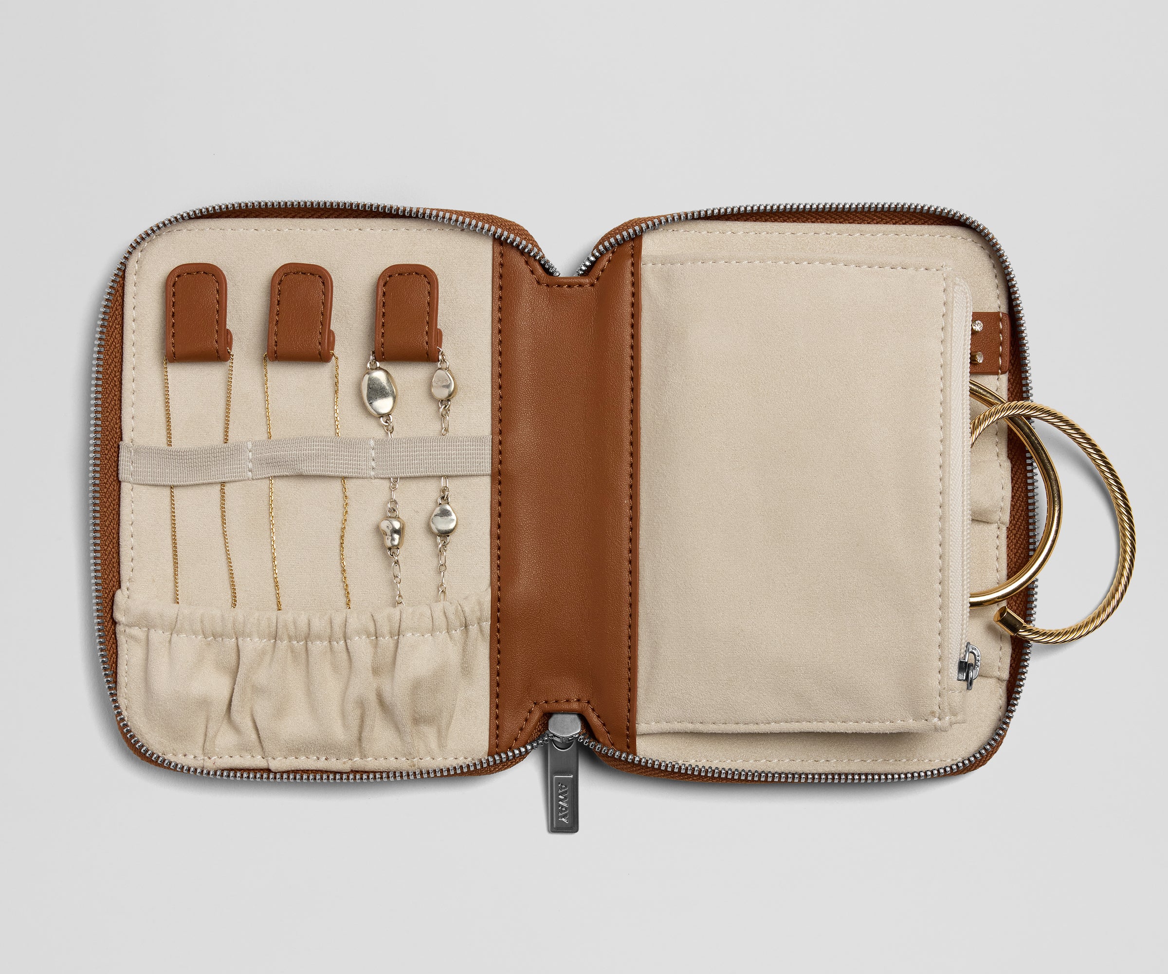 Jewelry case with jewelry items on a light gray background