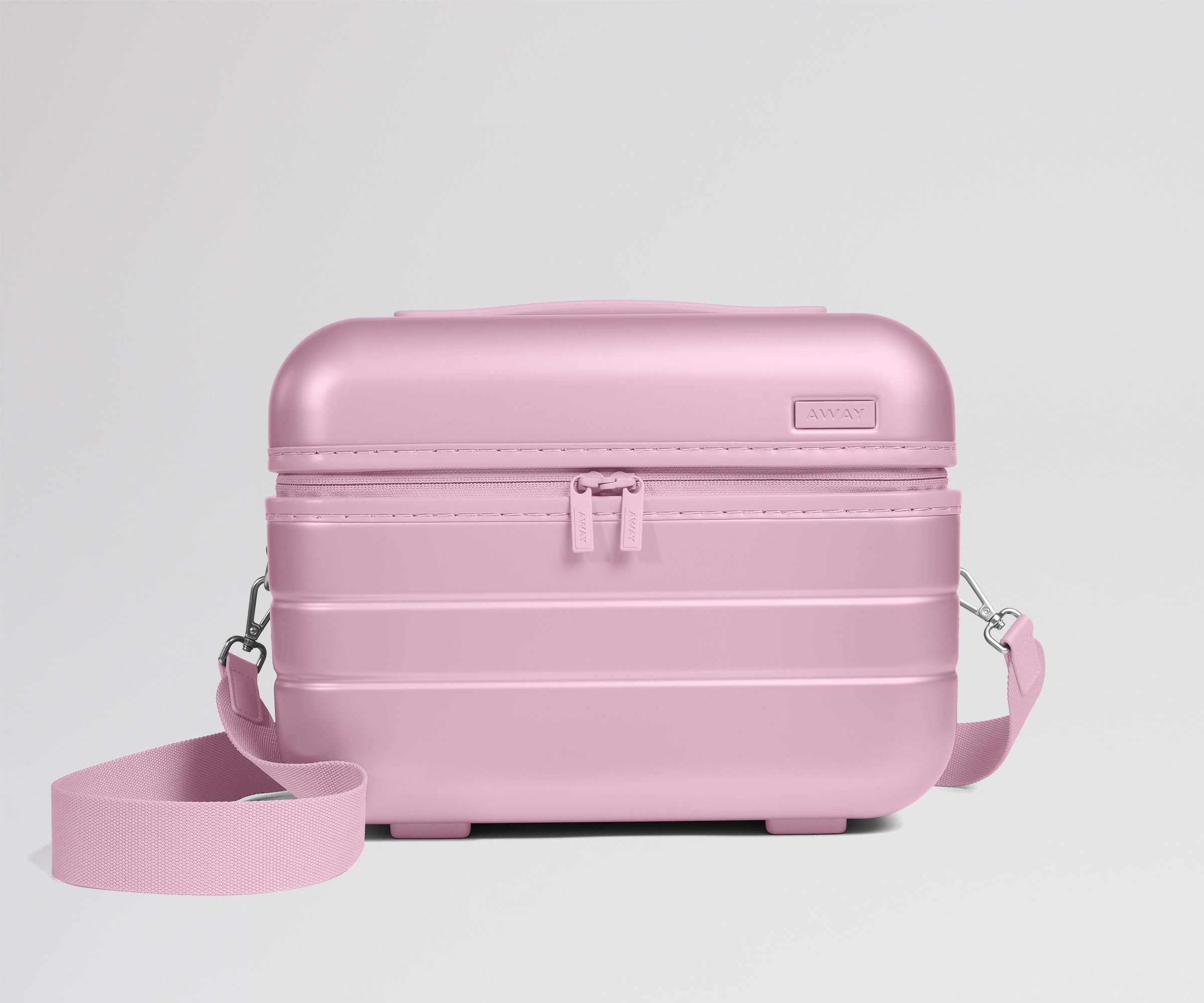 Pink travel case with a strap on a light gray background