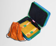 The Kids Carry-On suitcase in Splash Blue shown open and empty on its side to show capacity, and an orange laundry bag can double as a backpack for smaller travelers.