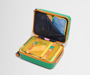 The Kids Carry-On suitcase in Froggy Green shown open on its side and packed with Away's packing organizers to show capacity and the interior compression system, designed to help you pack more in