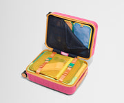 The Kids Carry-On suitcase in Cotton Candy Pink shown open on its side and packed with Away's packing organizers to show capacity and the interior compression system, designed to help you pack more in