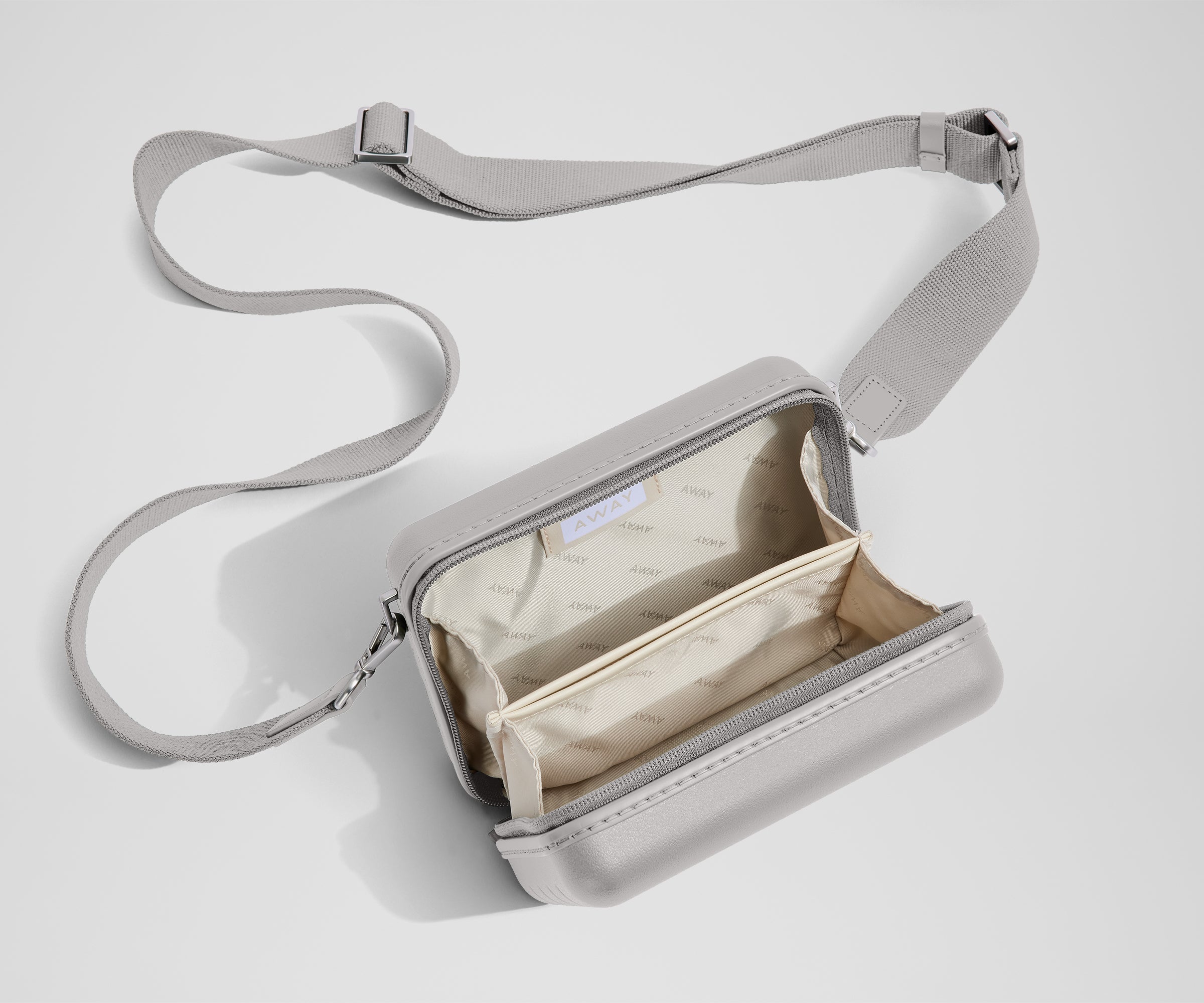 Unzipped, open view of The Mini Crossbody, showing the two main compartments and slip pocket