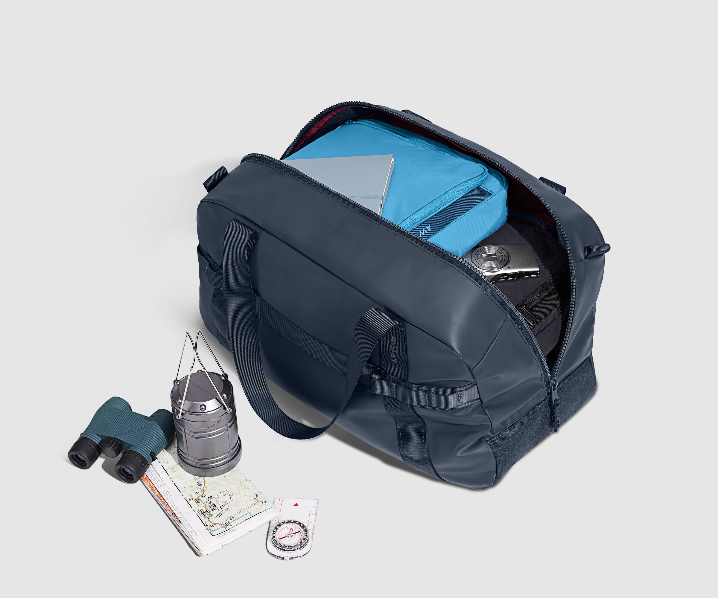 Navy Active Duffle 40L packed with packing cubes and other travel essentials including a notebook and camera.