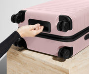 The Carry-On suitcase in Blush Pink shown from below highlighting the underside grab handle