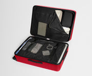 Red suitcase with open lid showing organized compartments on a light gray background