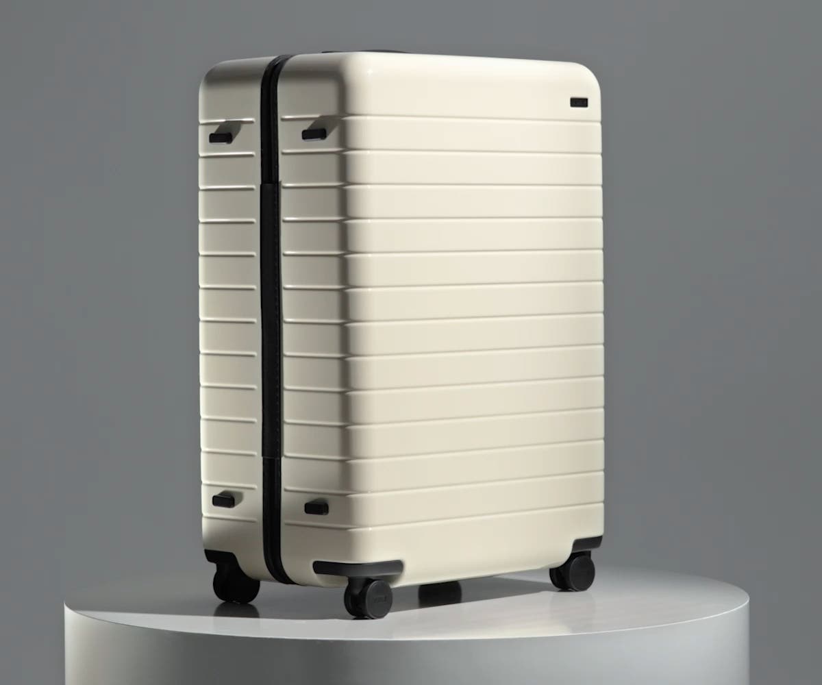 The Large suitcase in Salt White (Gloss) shown from below highlighting the underside grab handle