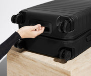The Carry-On suitcase in Jet Black shown from below highlighting the underside grab handle