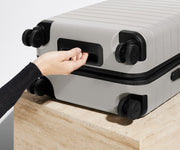 The Carry-On suitcase in Cloud Gray shown from below highlighting the underside grab handle