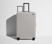 Front product view of The Large suitcase in Cloud Gray with raised handle