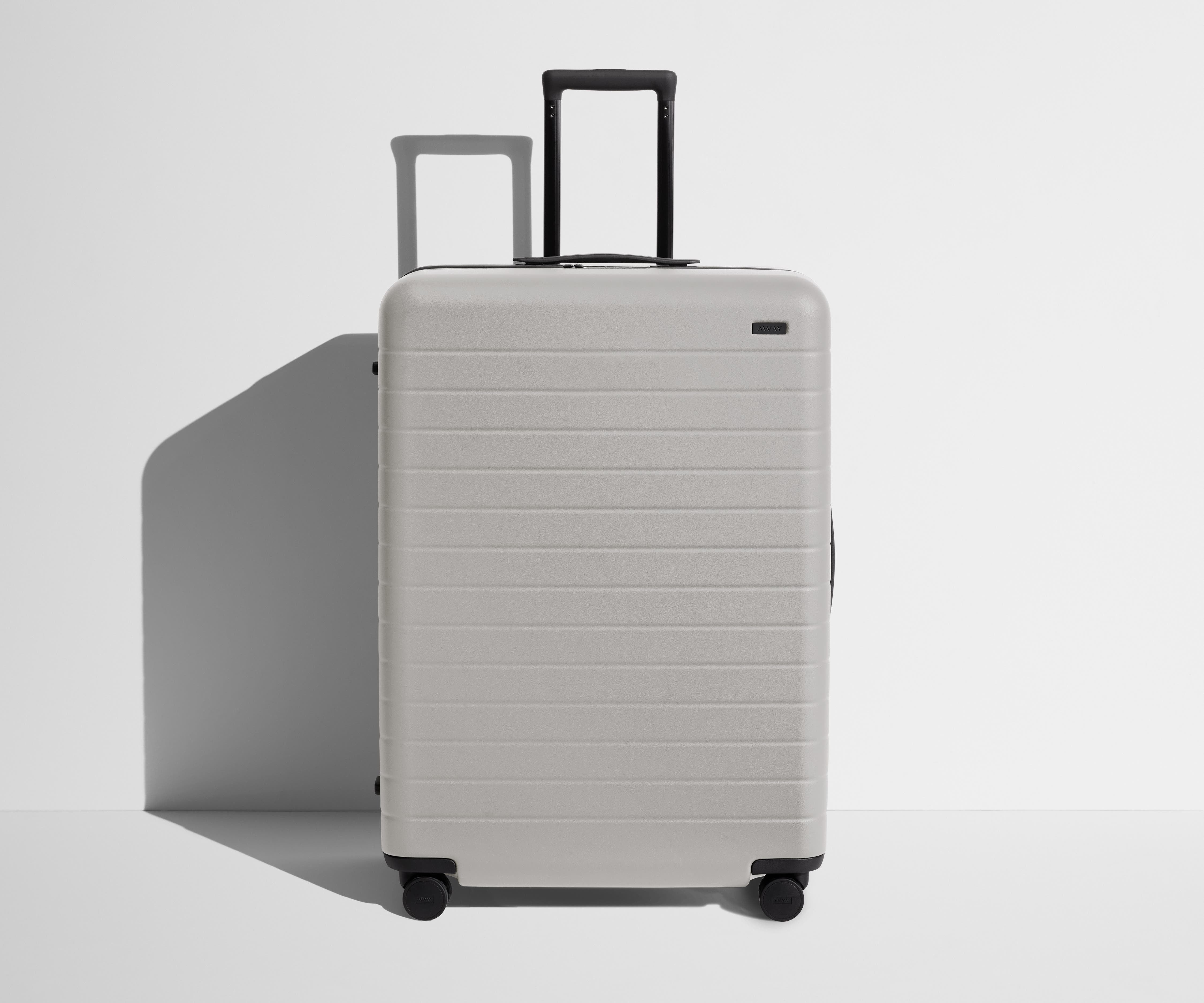 Front product view of The Large suitcase in Cloud Gray with raised handle