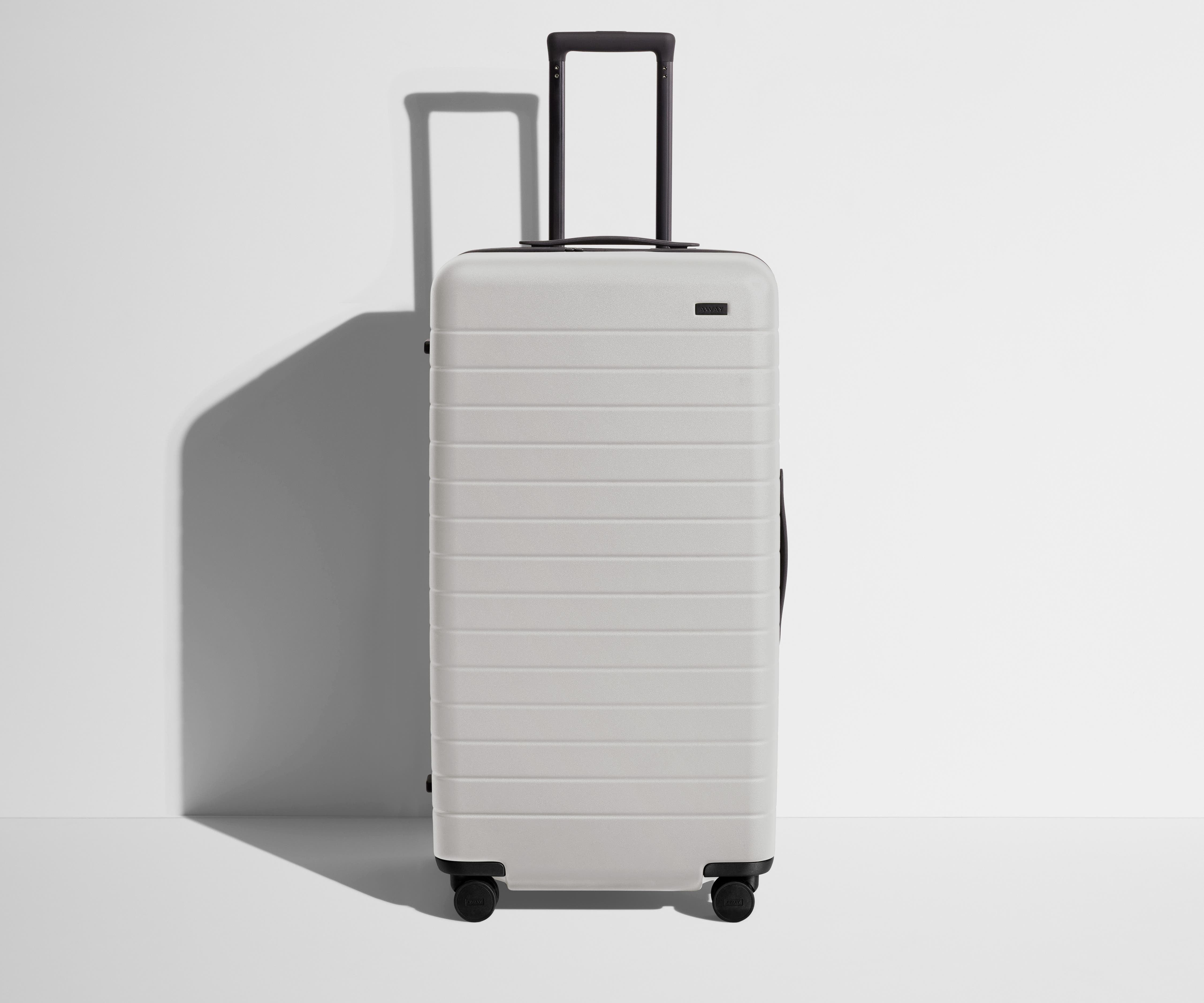 Front product view of The Trunk suitcase in Cloud Gray with raised handle