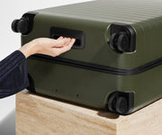 The Medium suitcase in Olive Green shown from below highlighting the underside grab handle