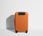 Back product view of The Bigger Carry-On Flex suitcase in Sorbet Orange
