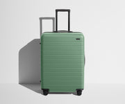 Front product view of The Medium suitcase in Sea Green with raised handle