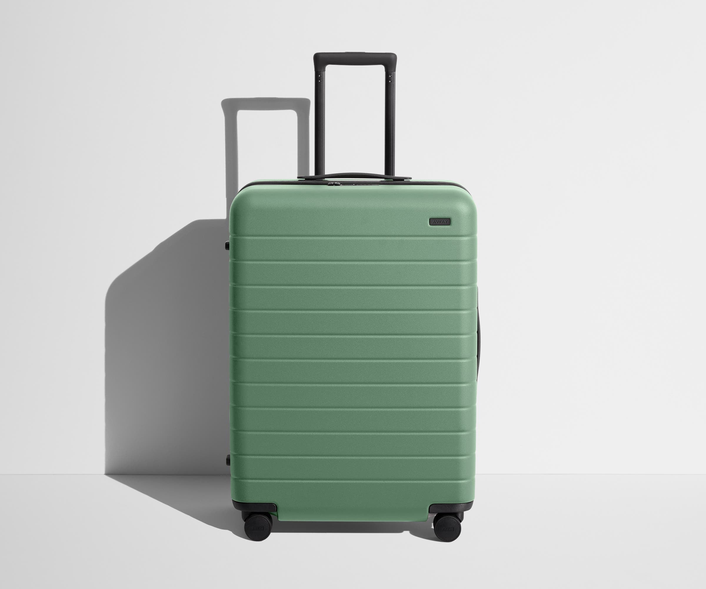 Front product view of The Medium suitcase in Sea Green with raised handle
