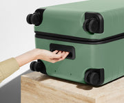 The Trunk suitcase in Sea Green shown from below highlighting the underside grab handle