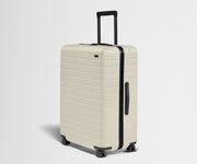 White suitcase with black handle and wheels on a light gray background
