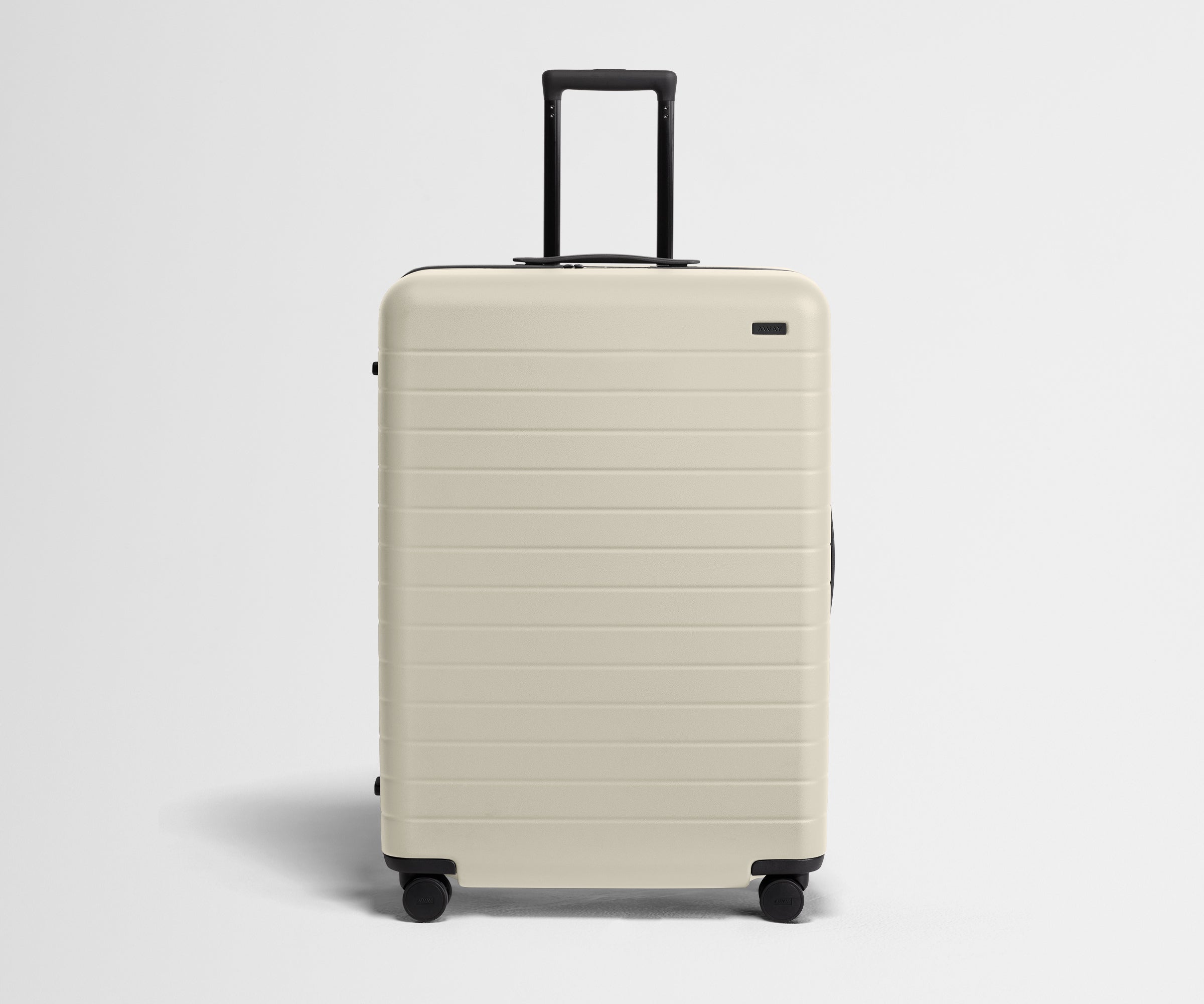 White suitcase with black handle on a light gray background