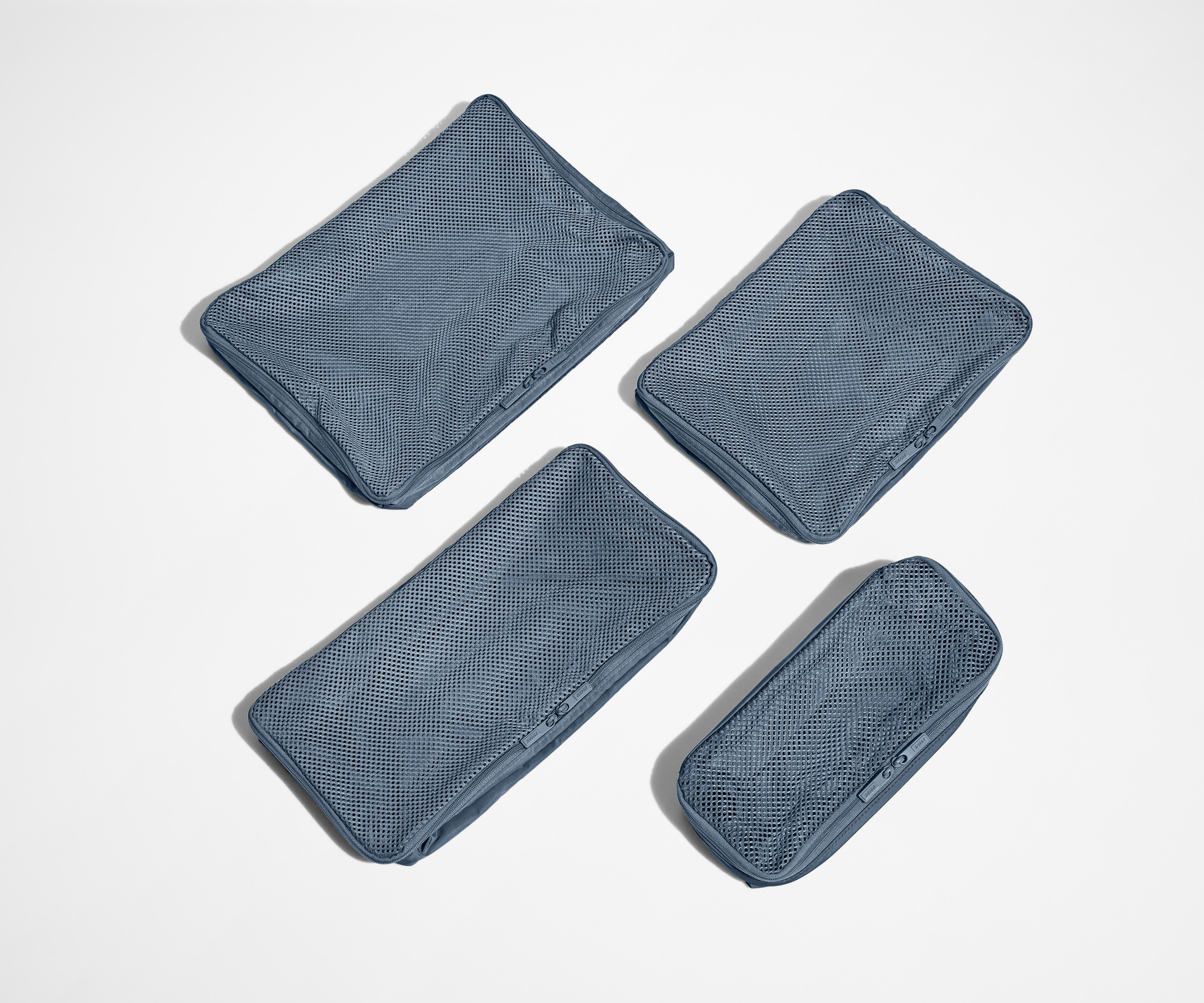 Set of four unpacked Packing Cubes laying flat