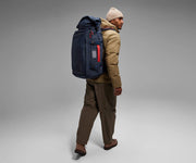 6'2" person wearing the 55L Boot Bag and winter clothes