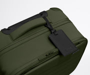 The Softside Compact Carry-On suitcase in Olive Green shown shown from above highlighting the recycled leather luggage tag