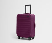 Angled product view of The Softside Bigger Carry-On suitcase in Plum Purple with raised handle