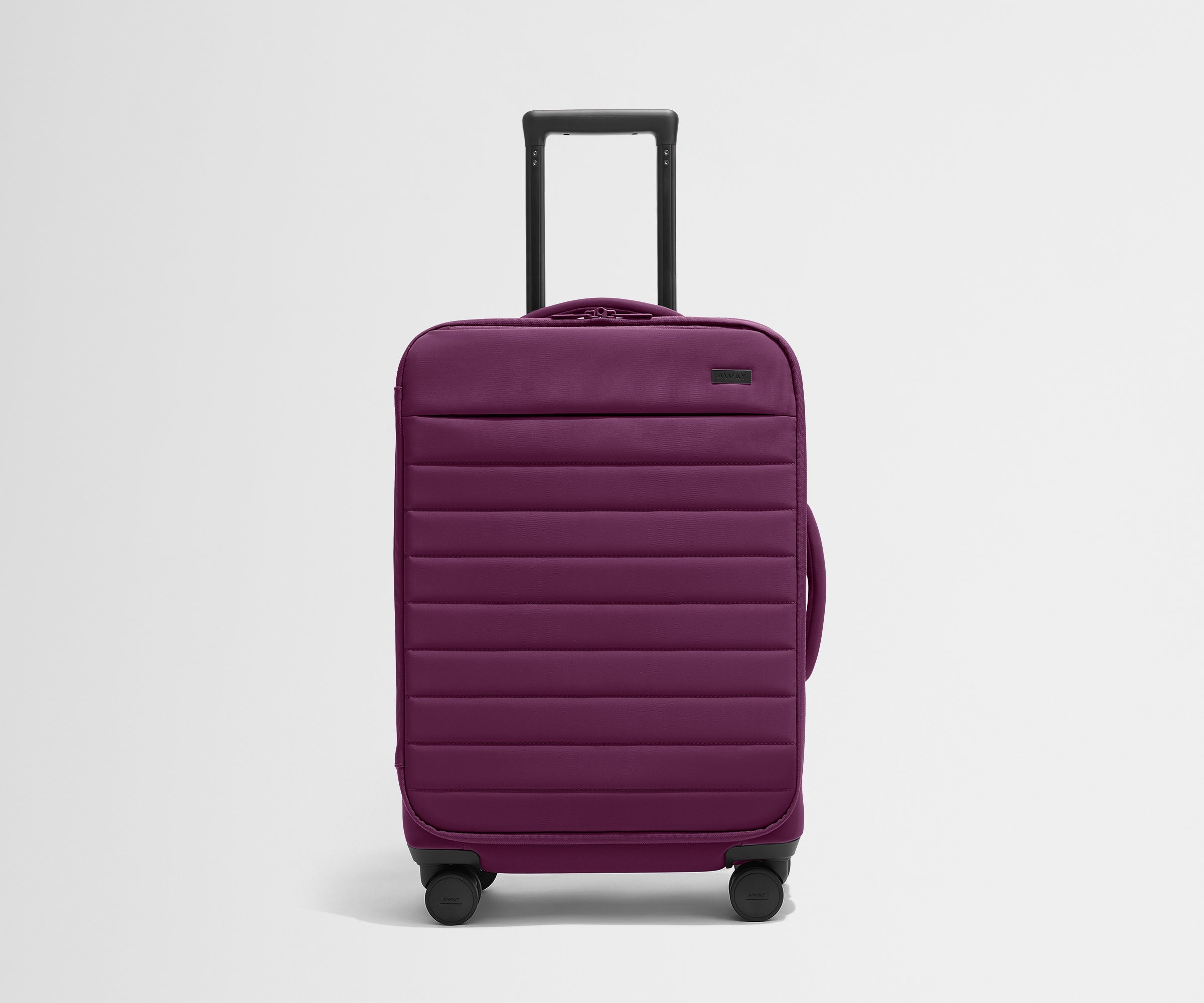 Front product view of The Softside Bigger Carry-On suitcase in Plum Purple with raised handle