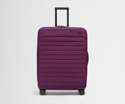 Front product view of The Softside Large suitcase in Plum Purple with raised handle