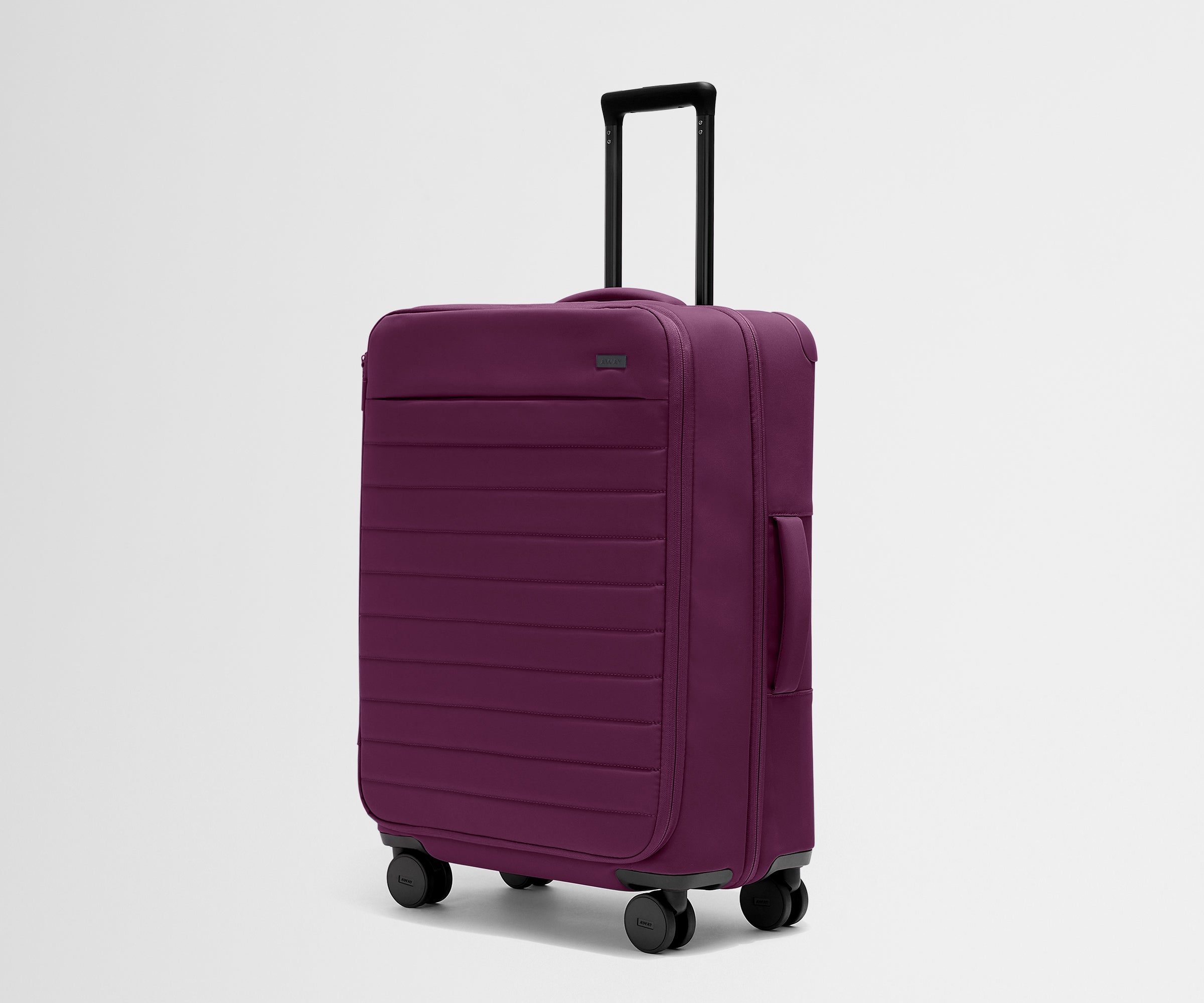 Angled product view of The Softside Medium suitcase in Plum Purple with raised handle