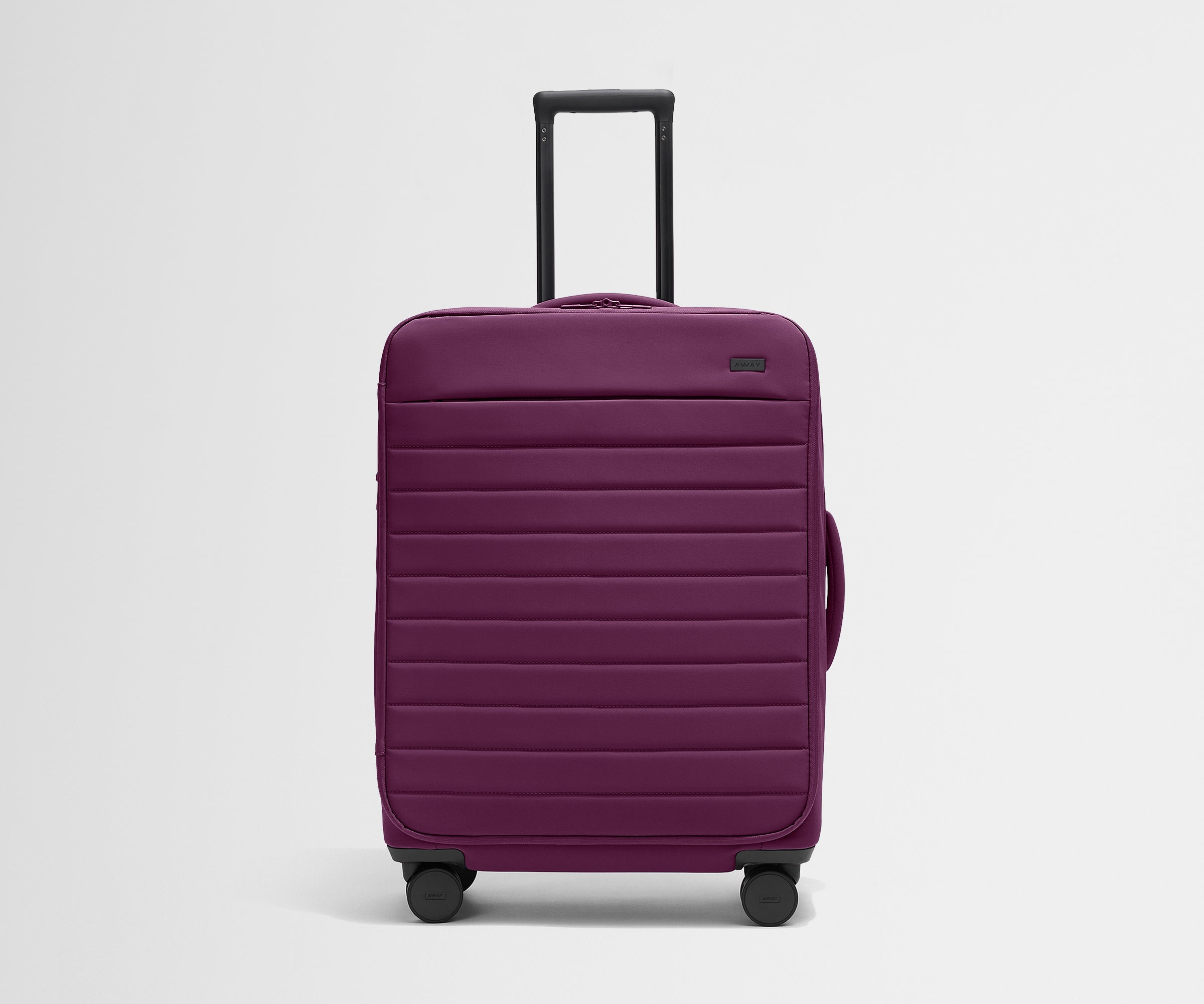Front product view of The Softside Medium suitcase in Plum Purple with raised handle