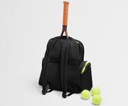 Black backpack with a tennis racket and balls on a light gray background