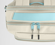 Close-up of a beige backpack with blue zippers on a light gray background