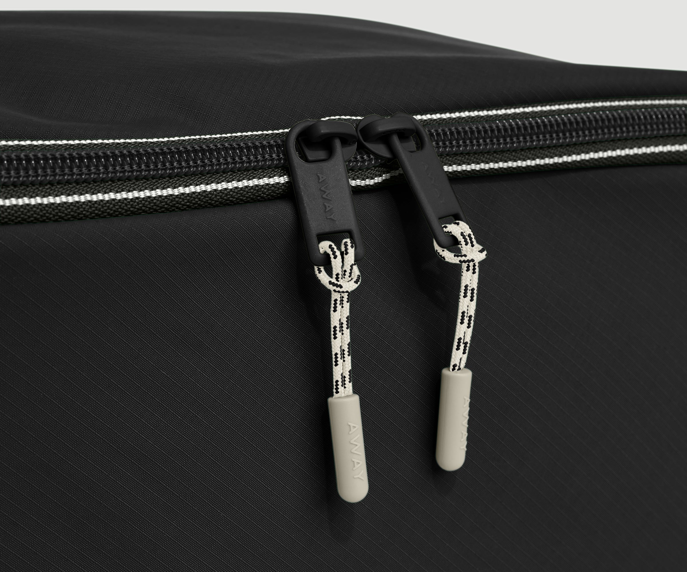 Close-up of a black shoe cube with zippers on a gray background