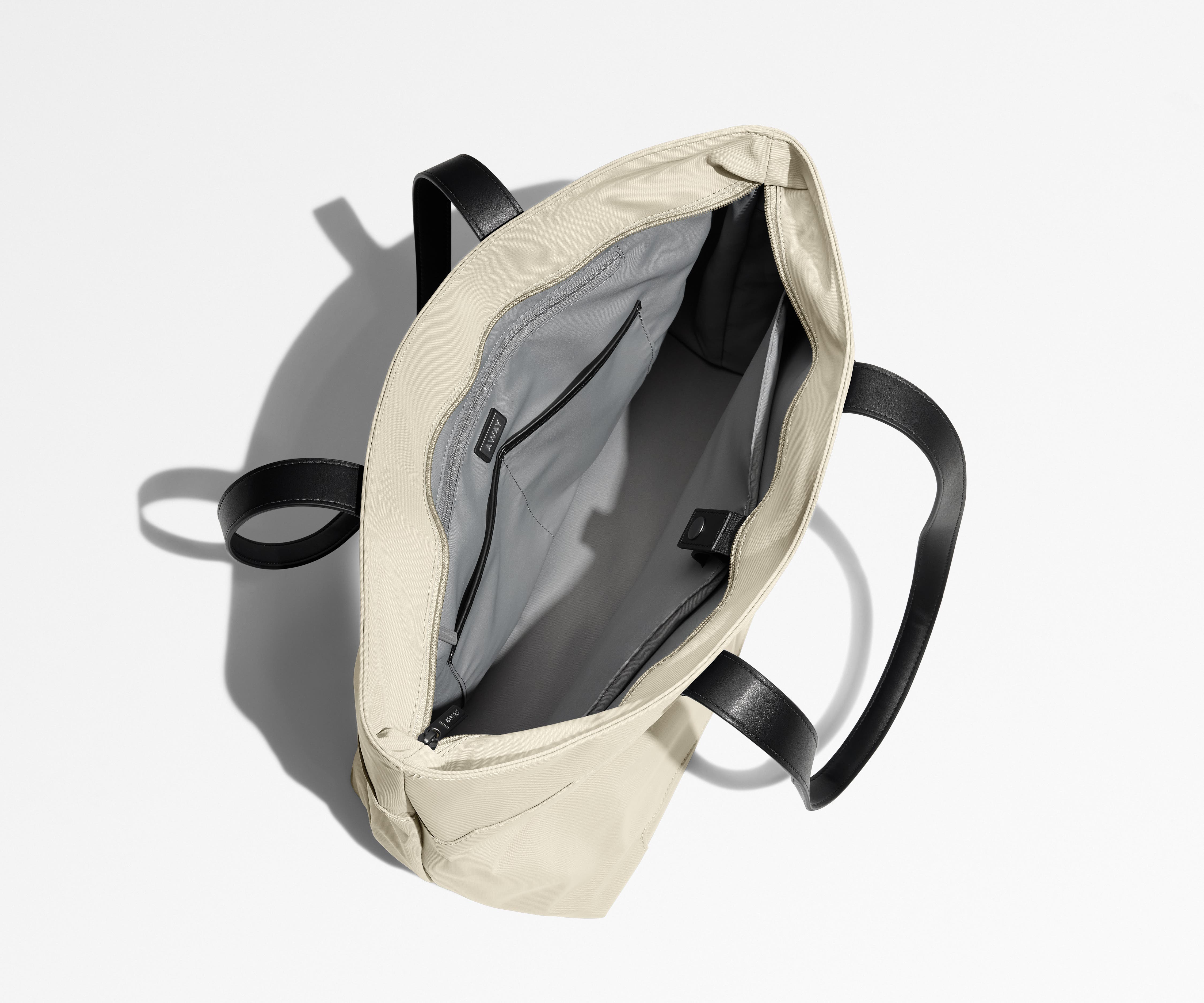 Unzipped and unpacked Everywhere Tote bag, showing the interior zip pockets, slip pockets, and laptop pocket