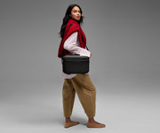 Person wearing the Train Case on their shoulder using the detachable shoulder strap