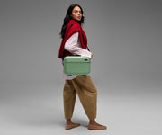 Person wearing the Train Case on their shoulder using the detachable shoulder strap