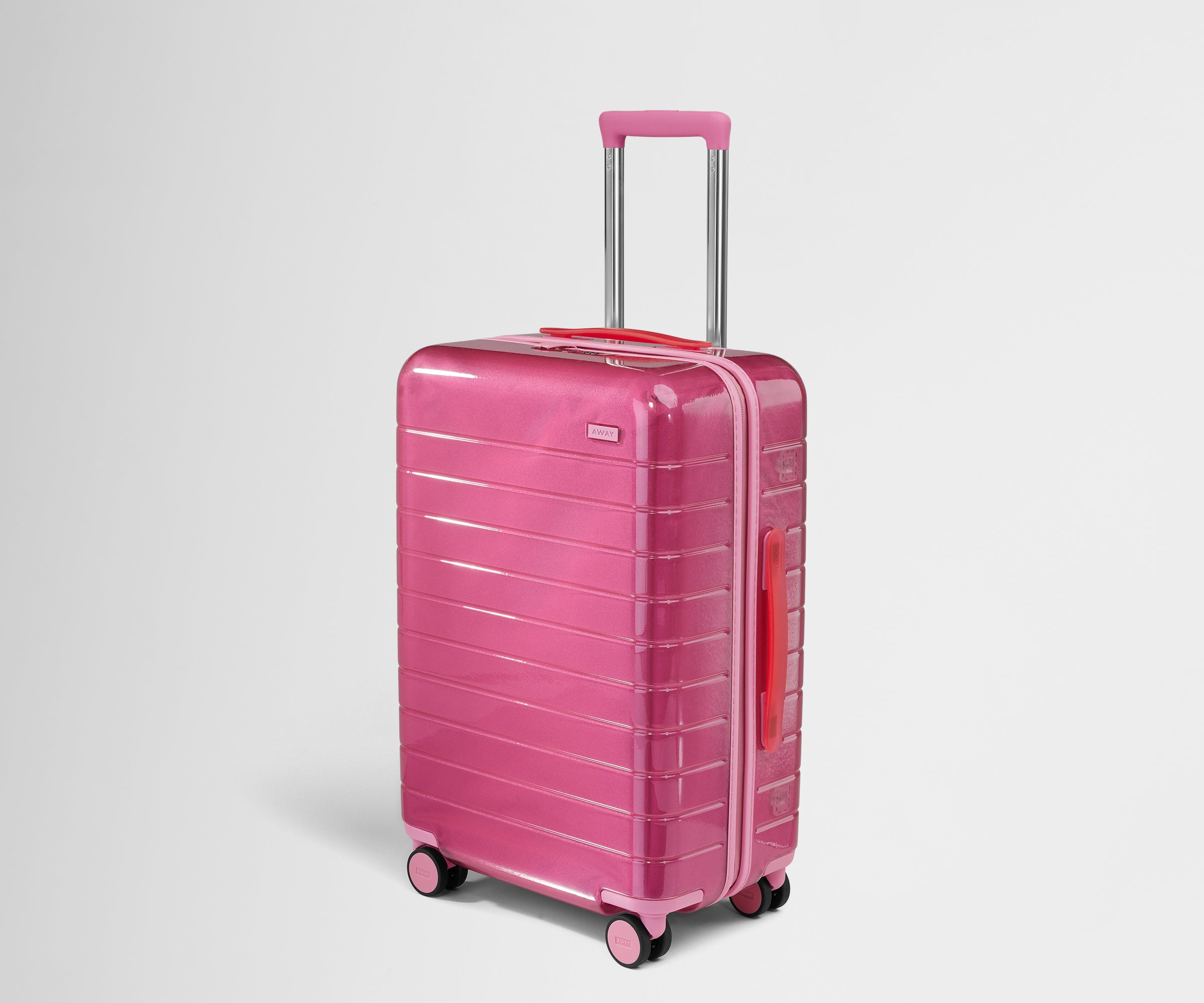 Angled product view of The Bigger Carry-On suitcase in Translucent Pink