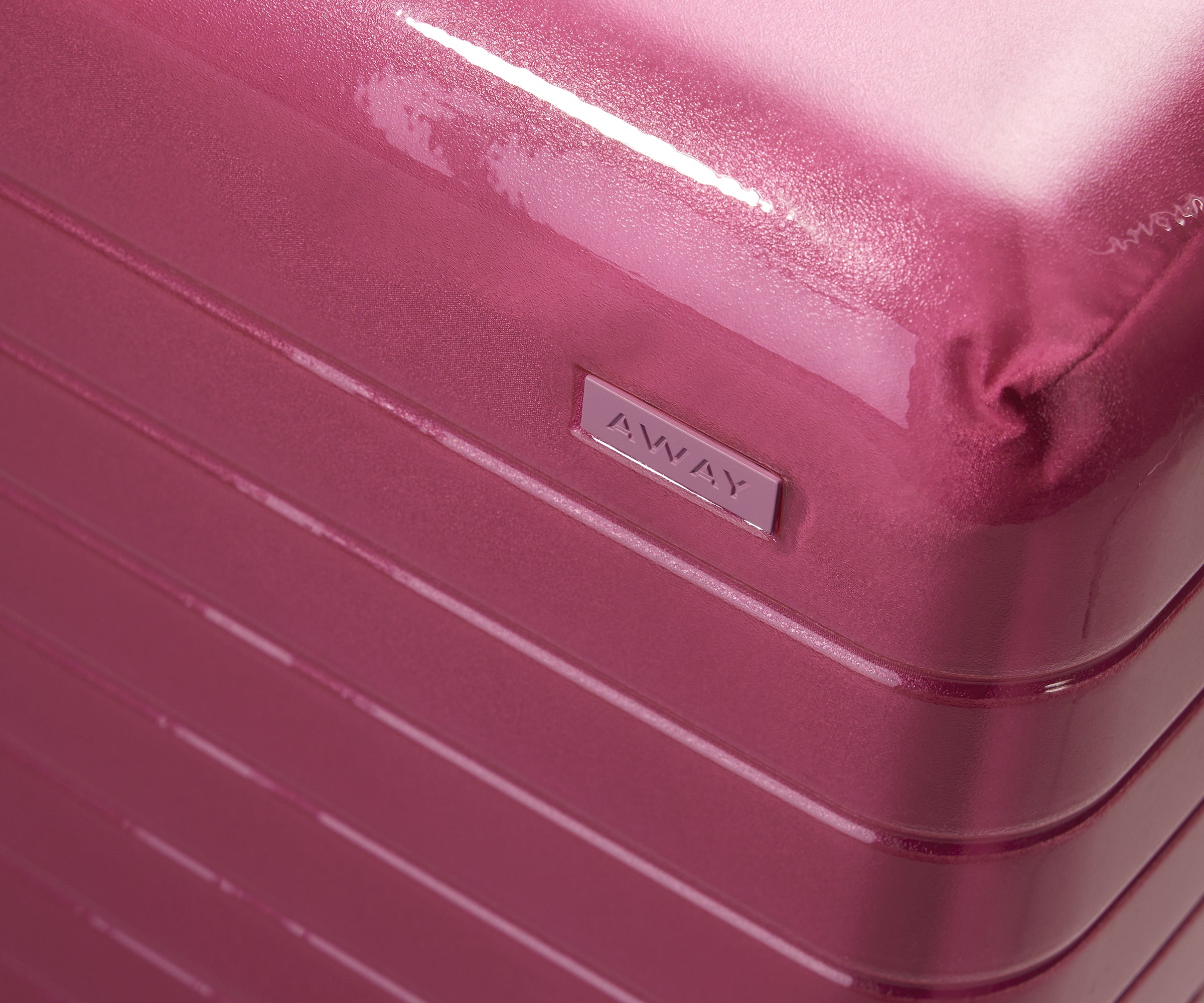 Zoomed in product view of The Carry-On suitcase in Translucent Pink to show the semi-transparent shell and opaque, color-matched interior lining