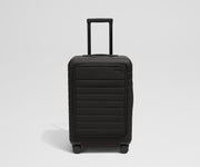 Front product view of The Front Pocket Bigger Carry-On suitcase in Jet Black with raised handle