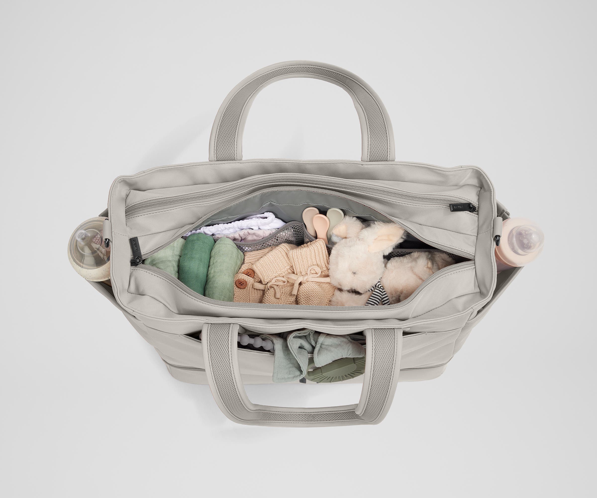 Front main compartment packed with child essentials, including a stuffed animal, wipes, and change of clothes