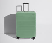 Front product view of The Large Flex suitcase in Sea Green with raised handle