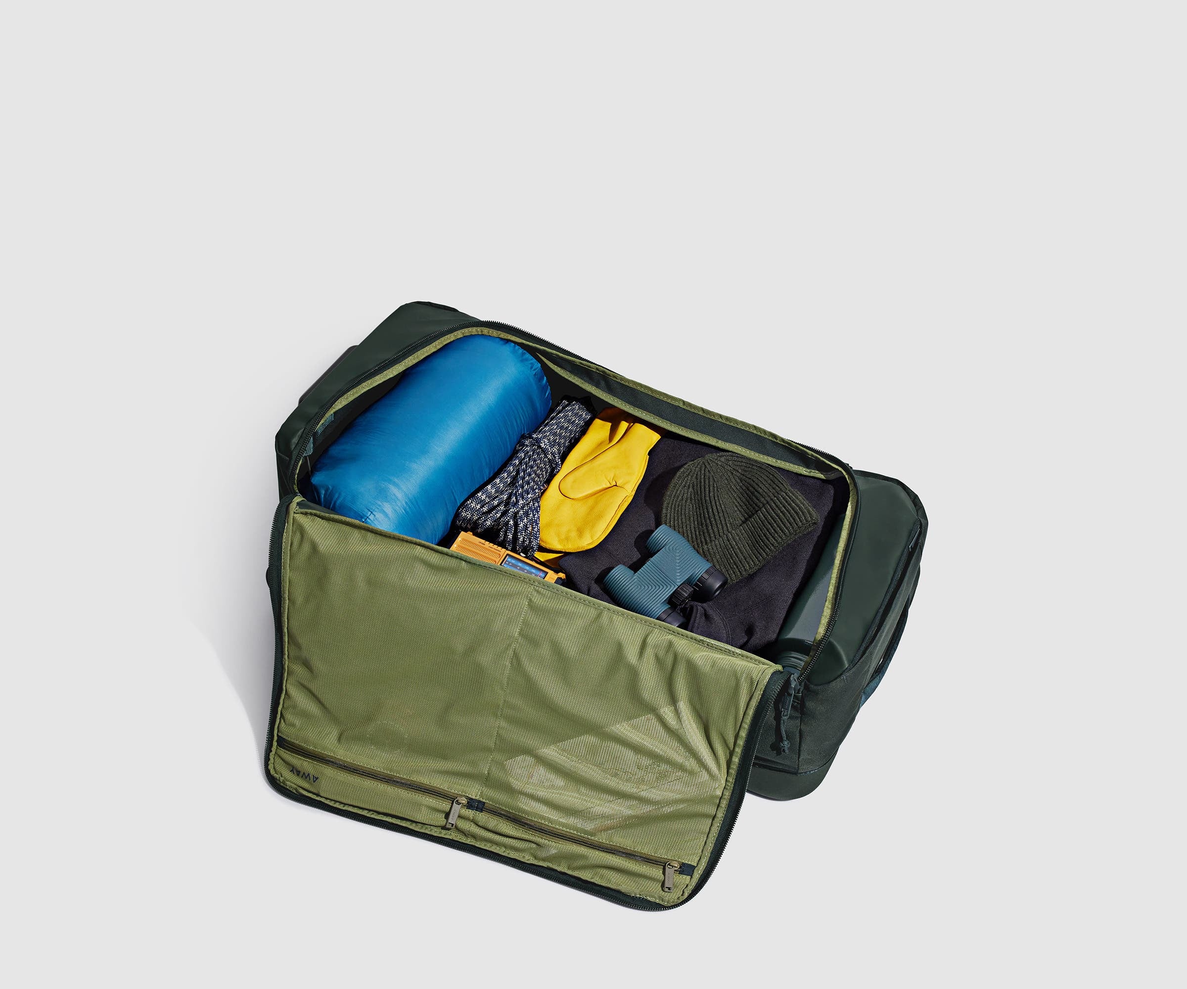 85L rolling duffle bag packed with a sleeping bag, outdoor gear, and clothing