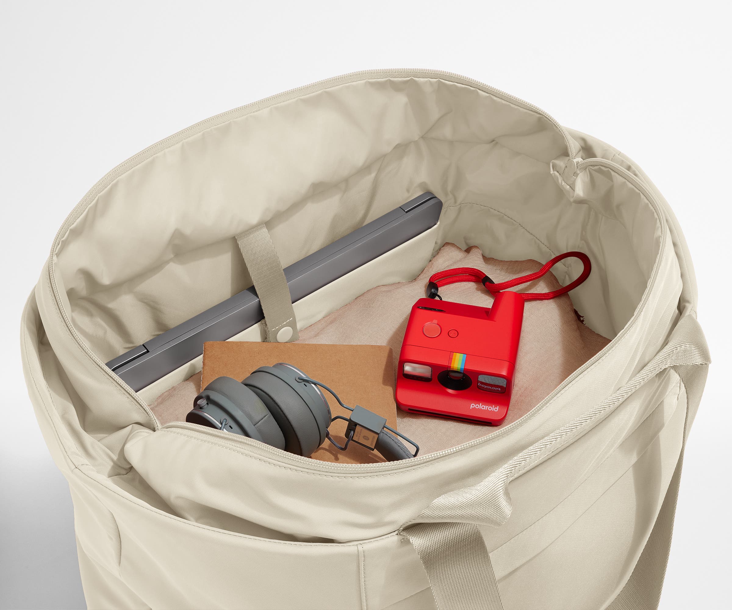 Interior packed with clothing, a laptop, headphones, notebook, and camera