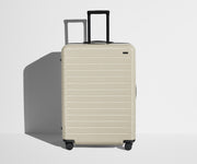 Front product view of The Large suitcase in Salt White (Gloss) with raised handle