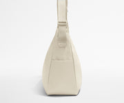 Side view of the Large Featherlight Crossbody showing the exterior bottle pocket