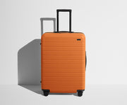 Front product view of The Medium suitcase in Sorbet Orange with raised handle
