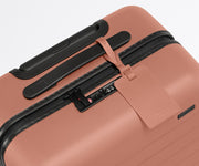 The leather luggage tag on top of a matching Away suitcase