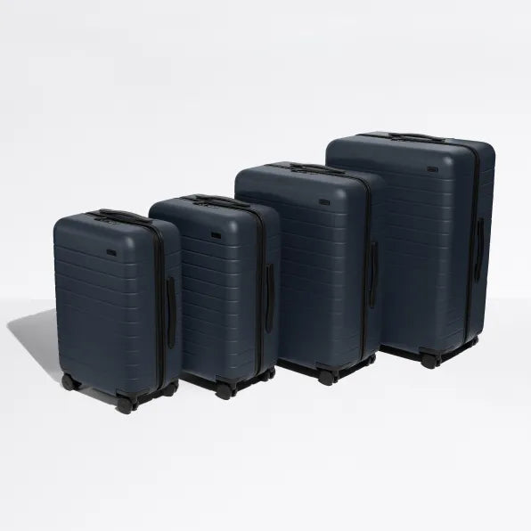 A set of 4 Away suitcases in navy blue against a white background